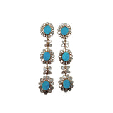 Pair of floral earrings with turquoise centers surrounded by diamond slices on a white background