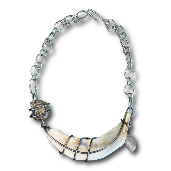 The back side of a silver chain necklace featuring a large curved shell pendant wrapped in dark wire, with a small textured shell accent and a small leaf charm, shown on a plain white background.